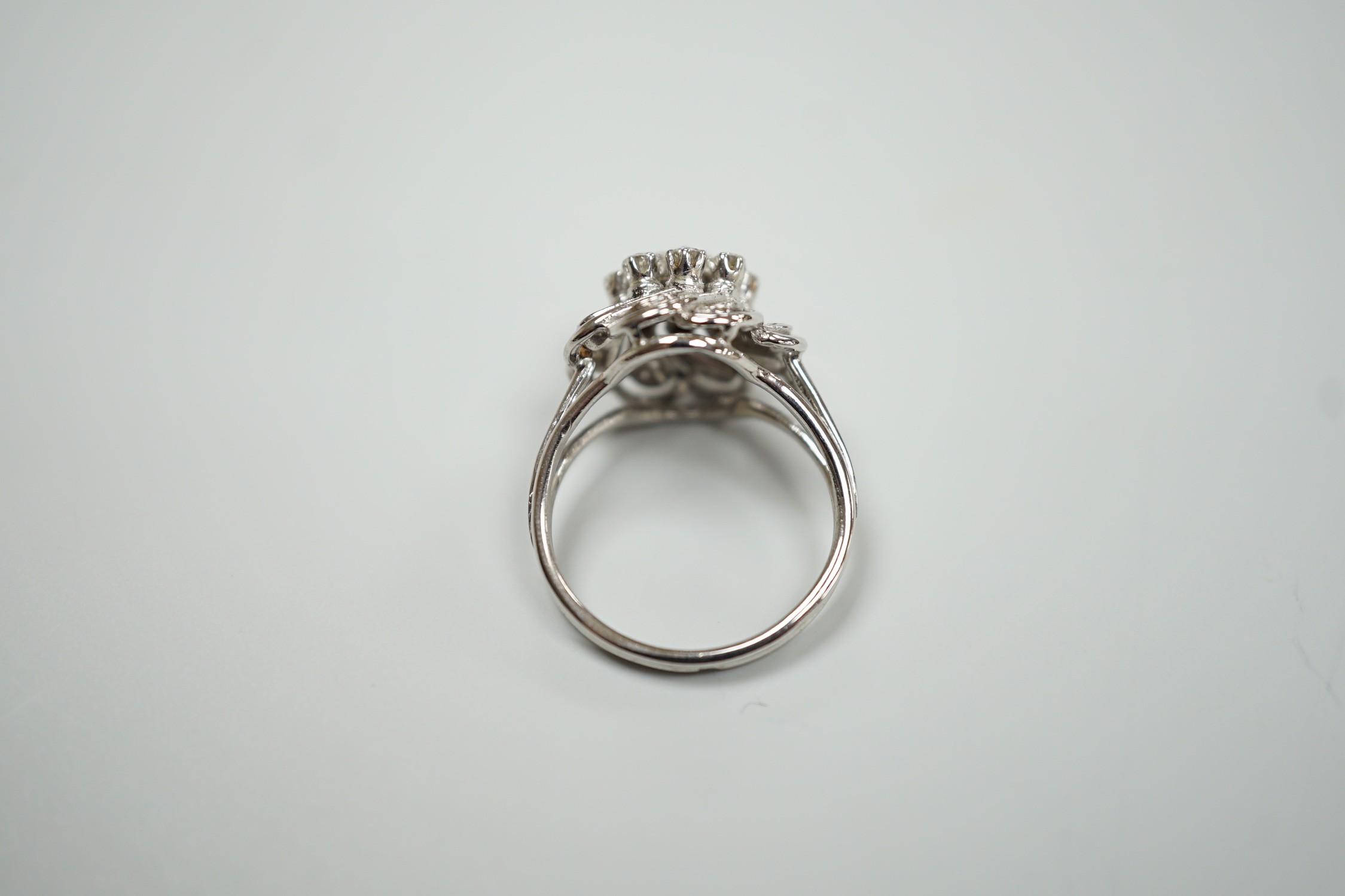 A French white metal (18ct poincon mark) and diamond cluster set dress ring, size L/M, gross weight4.8 grams.